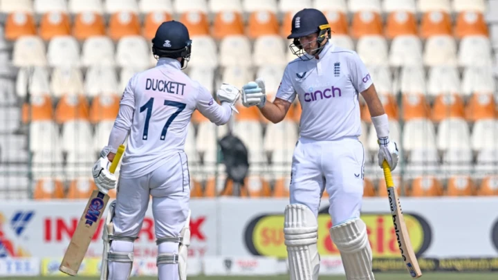 England's Joe Root (R) is congratulated by Ben Duckett after breaking Alastair Cook's England Test runs record during the third day of the first Test cricket match between Pakistan and England at the Multan Cricket Stadium in Multan on October 9, 2024. Joe Root broke Alastair Cook's England Test record of 12,472 runs on the third day of the opening Test against Pakistan in Multan on October 9. Photo: AFP