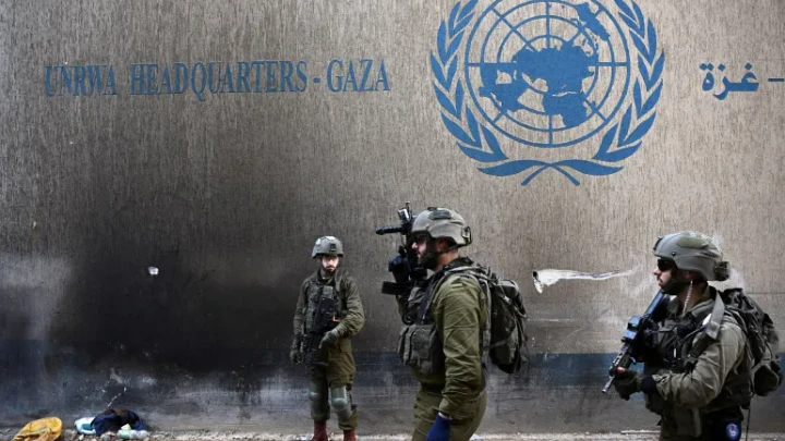 Israeli soldiers operate next to the UNRWA headquarters in the Gaza Strip, in February 2024 [File: Dylan Martinez/Reuters]