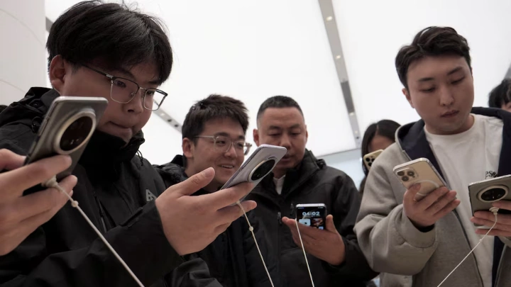  Visitors look at Huawei's newly unveiled Mate 70 smartphone series at a flagship store in Beijing, China November 26, 2024. REUTERS/Xiaoyu Yin/File Photo 