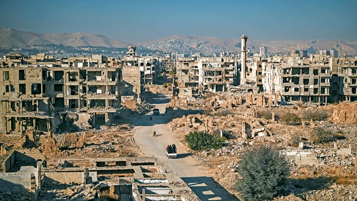 A family stands at the destroyed cemetery in the Syrian town of Jobar in Eastern Ghouta on the outskirts of Damascus on Wednesday. Islamist-led rebels took Damascus in a lightning offensive on December 8, ousting president Bashar al-Assad and ending five decades of Baath rule in Syria. | AFP photo