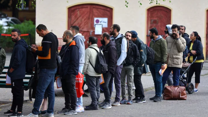 Migrants queue in a waiting area to be escorted to a registration office at the arrival centre for asylum seekers in Reinickendorf district, Berlin, Germany, October 6, 2023. REUTERS/Fabrizio Bensch/File Photo