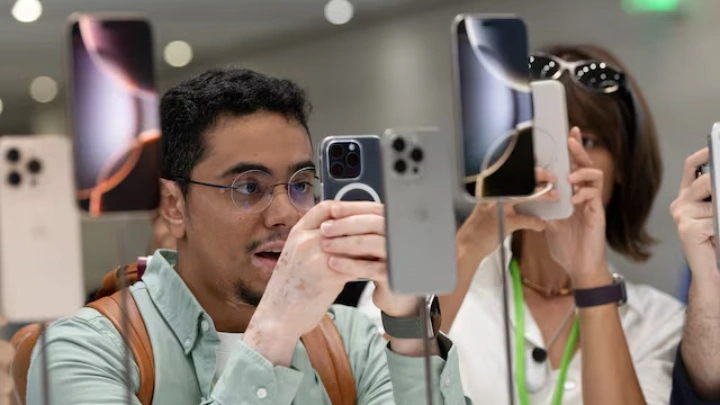 An attendee takes a photo of the new iPhone 16 as Apple holds an event at the Steve Jobs Theater on its campus in Cupertino, California, U.S. September 9, 2024. REUTERS/Manuel Orbegozo/File Photo