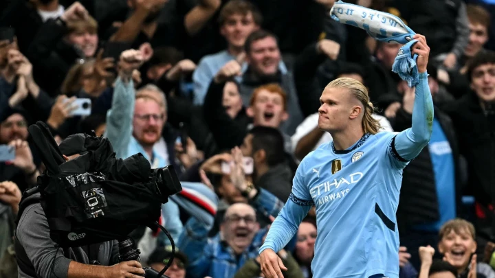 Erling Haaland celebrates after scoring the team's first goal and his 100th for Manchester City, waving City scarf aloft, during the English Premier League match against Arsenal at the Etihad Stadium on September 22, 2024. PHOTO: AFP